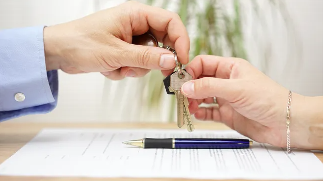 Two hands exchanging keys, completing a 1031 exchange.
