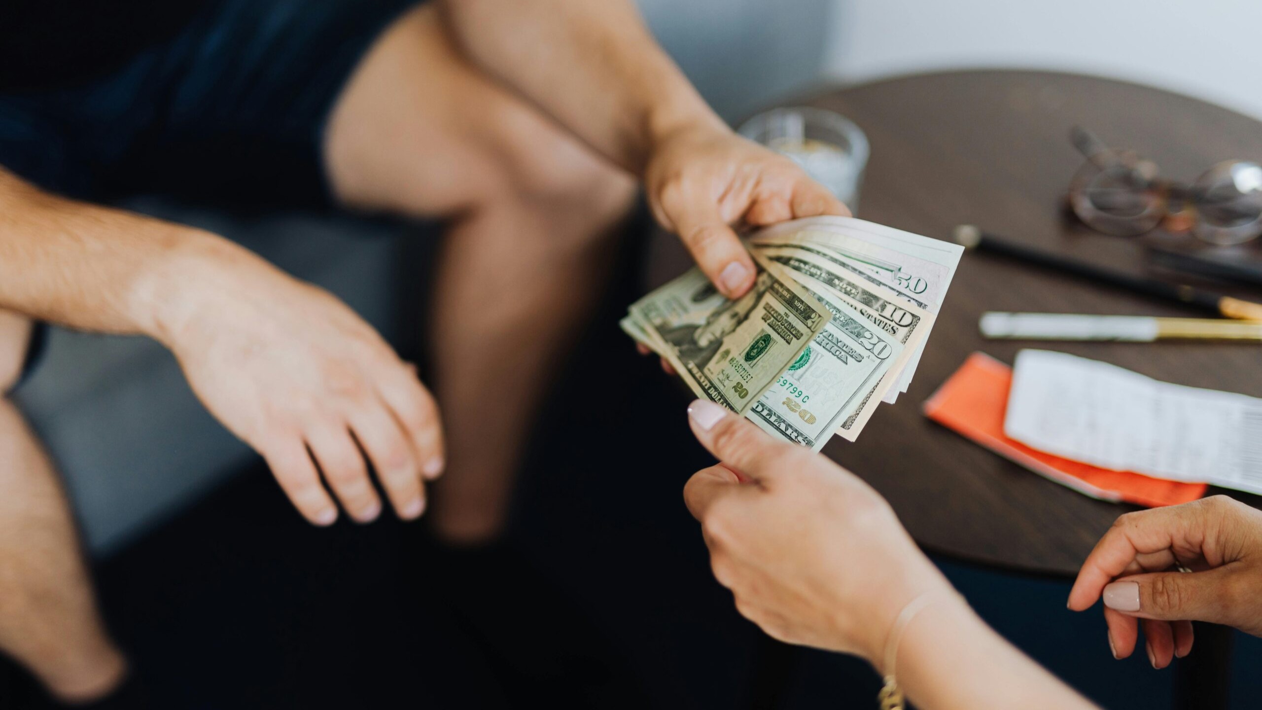 Two people exchanging cash in a casual transaction.