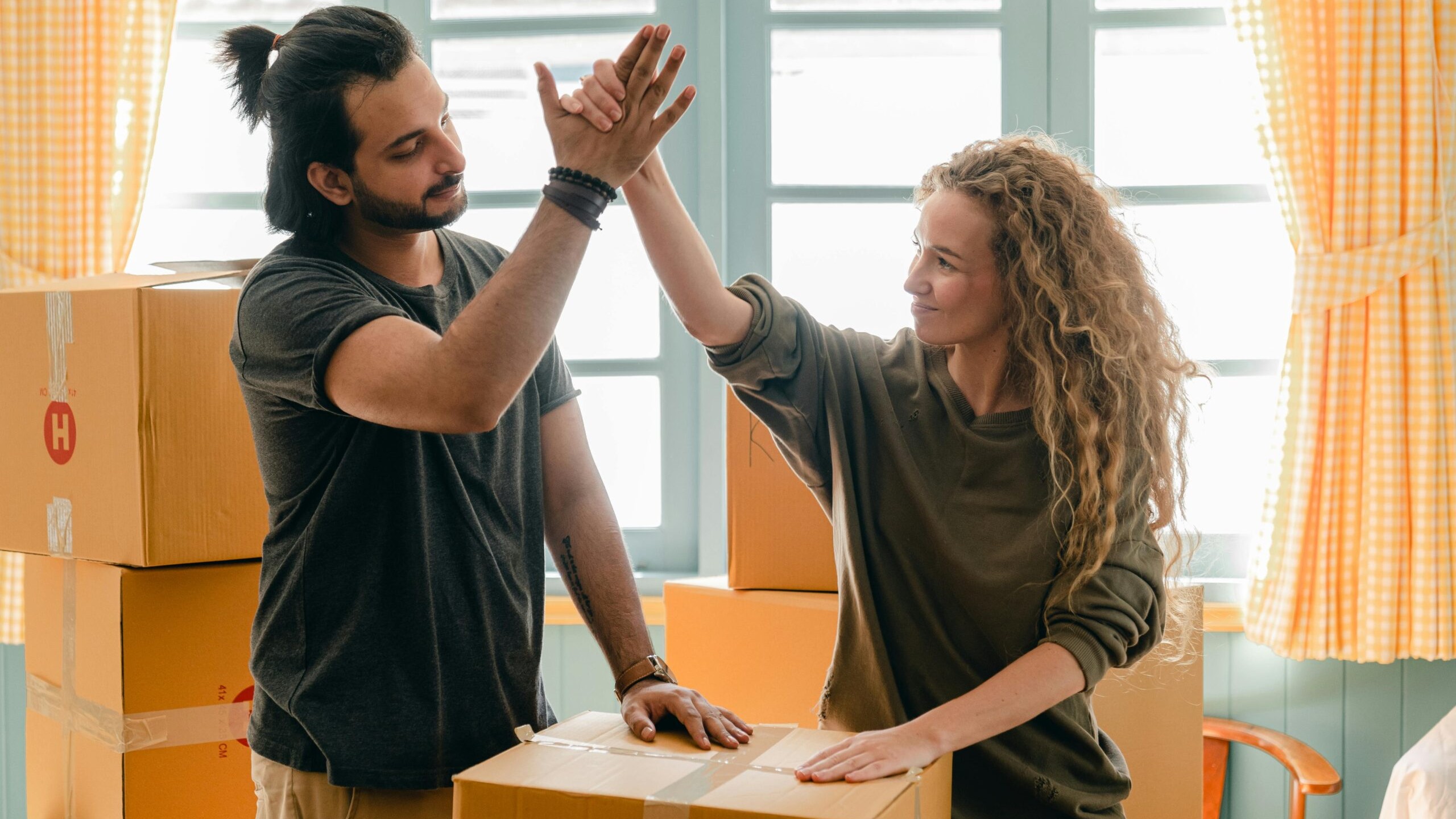 A young couple that has recently moved into their live-in-then-rent strategy property, celebrating together.