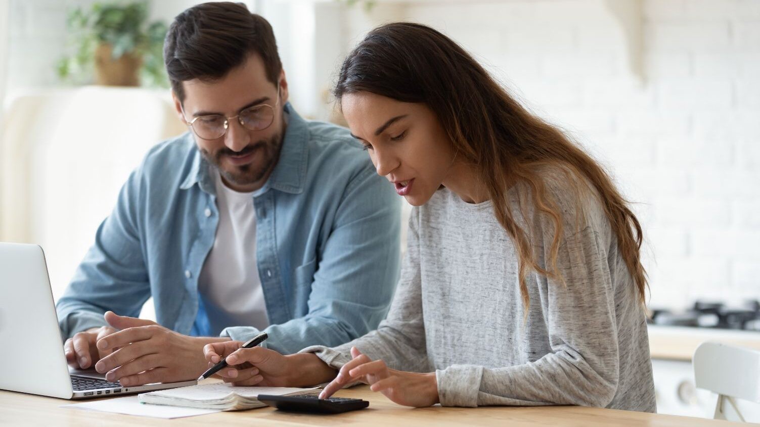 A couple calculating cash on cash return for their rental properties while sitting at a table.